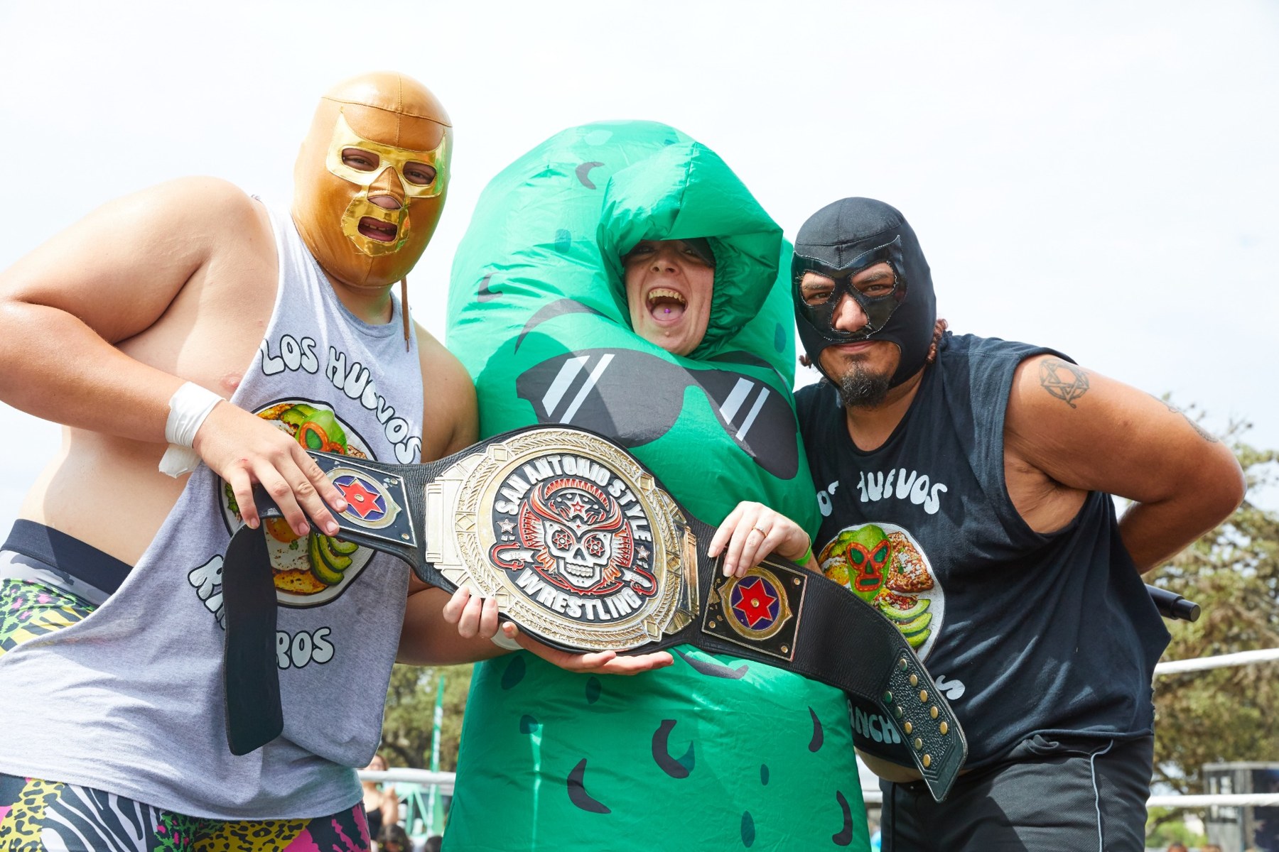 Wrestlers posing with the pickle mascot