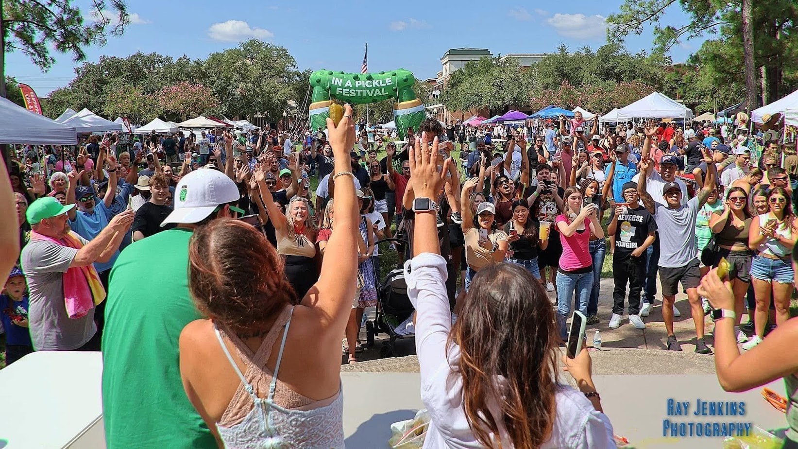 Cheering crowd beneath the giant pickle entrance