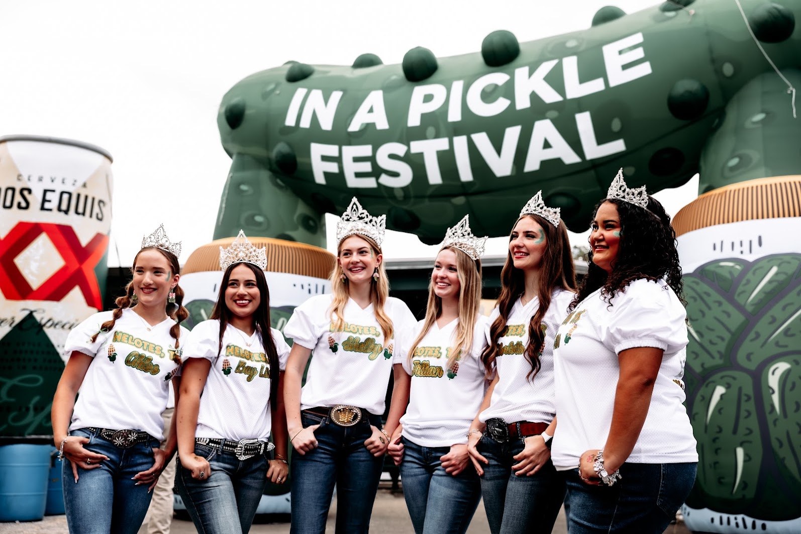 Guests posing together beneath the giant pickle entrance