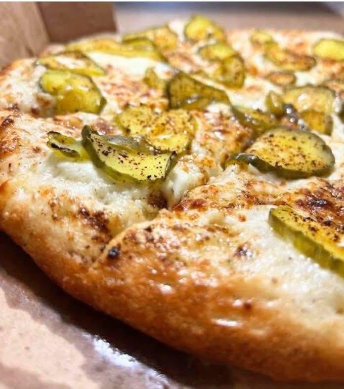 Freshly baked pizza topped with pickle slices